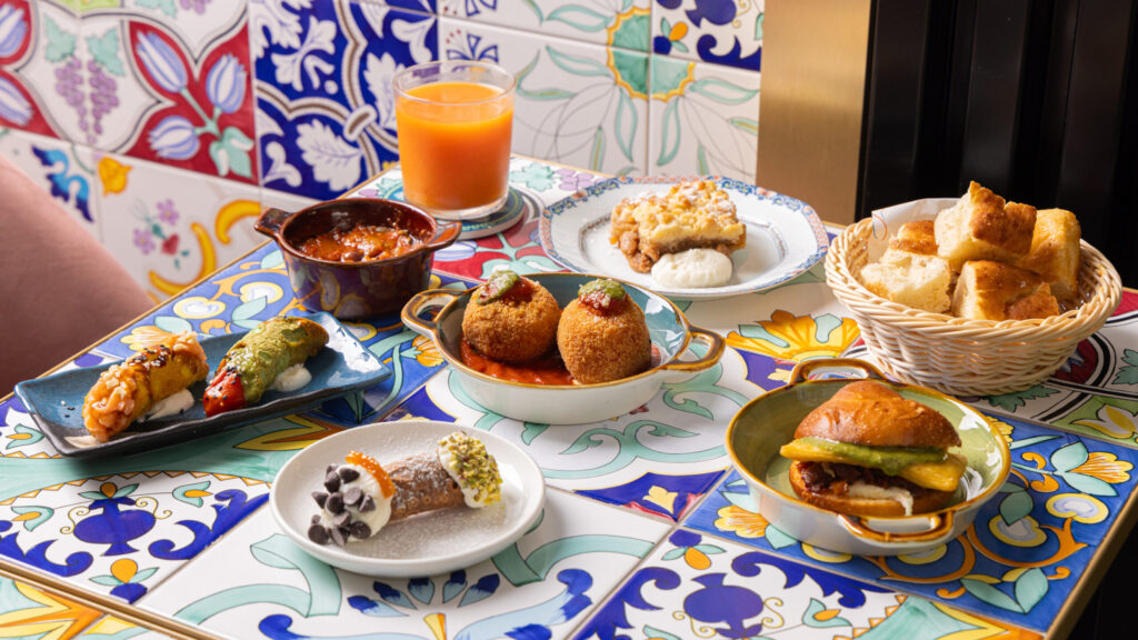 Cannoli salati, arancine, brioche col tuppo e cannolo dolce sulle maioliche di Talè Milano